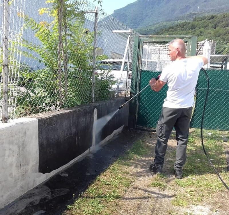Employé utilisant un karcher lors de nettoyage mobilier urbain, Isère