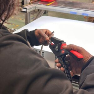 Prestataire de services Grenoble avec employé dénudant un fil électrique